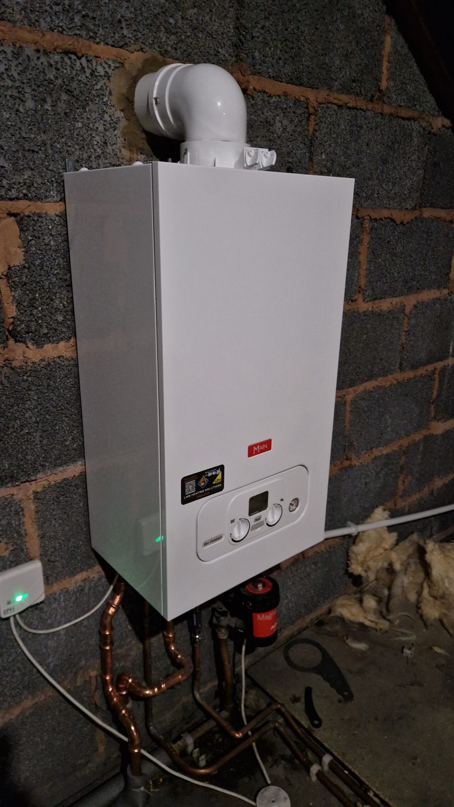 Newly installed gas boiler with a white flue and copper pipework