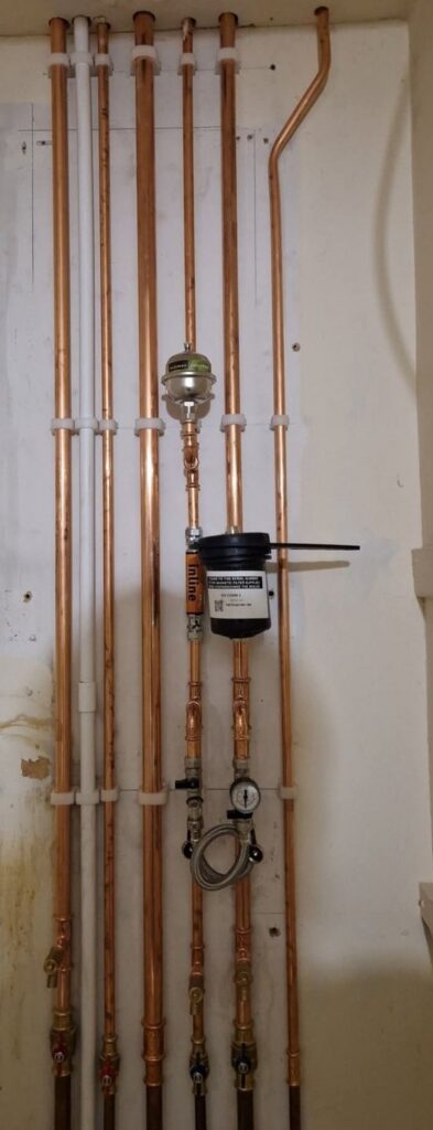Copper pipework and magnetic filter fitted in a cupboard